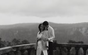Scenic mountain overlook with dramatic cloudy skies and rolling hills.