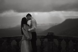 Dramatic black and white wedding portraits against a mountainous landscape at sunset.
