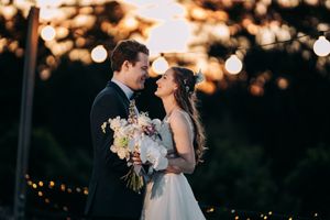Romantic sunset wedding portraits with string lights creating a dreamy atmosphere.