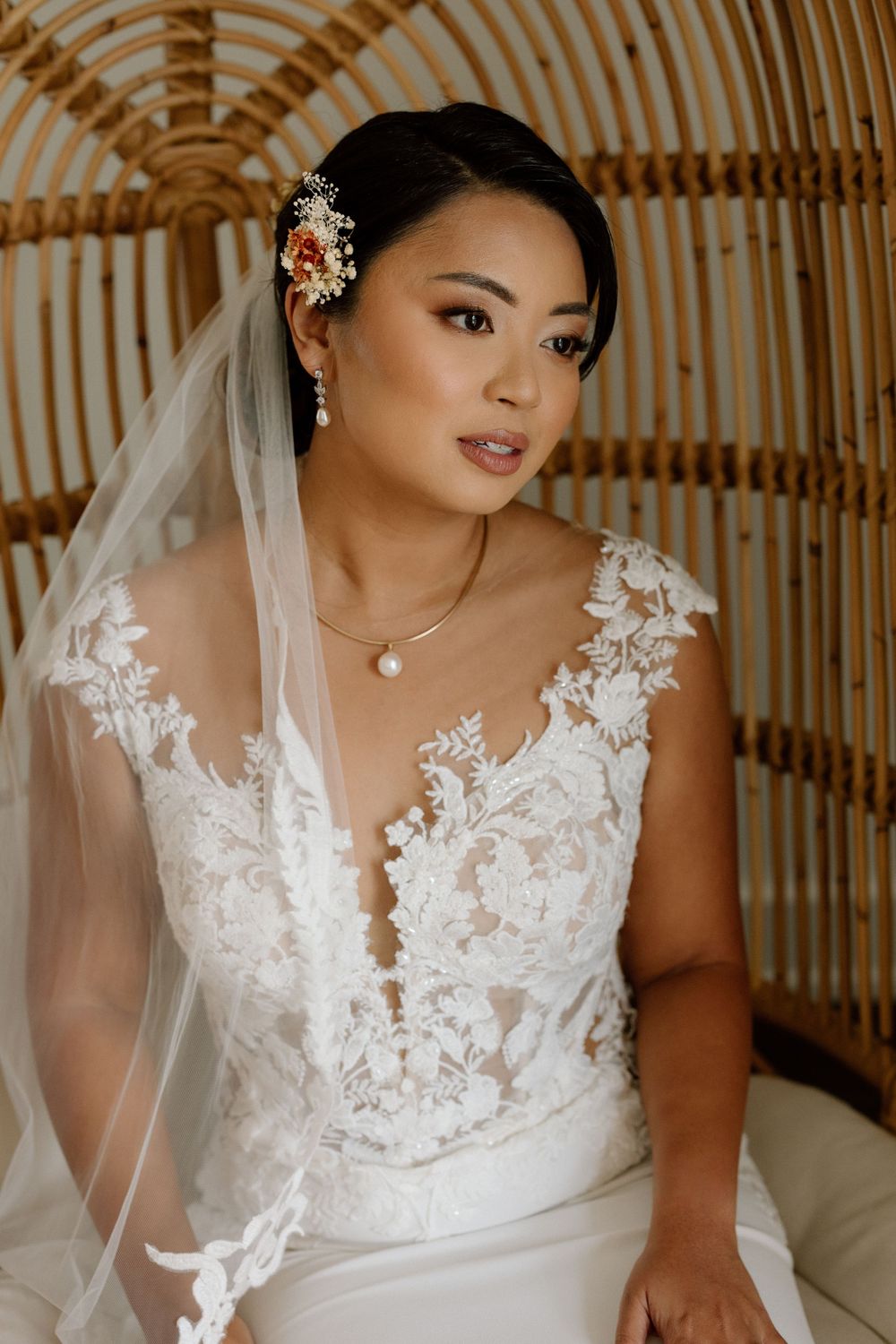 Bridal portrait showcasing elegant lace dress, veil and floral hair accessories.