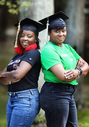 Two graduates in caps strike confident poses in casual attire.