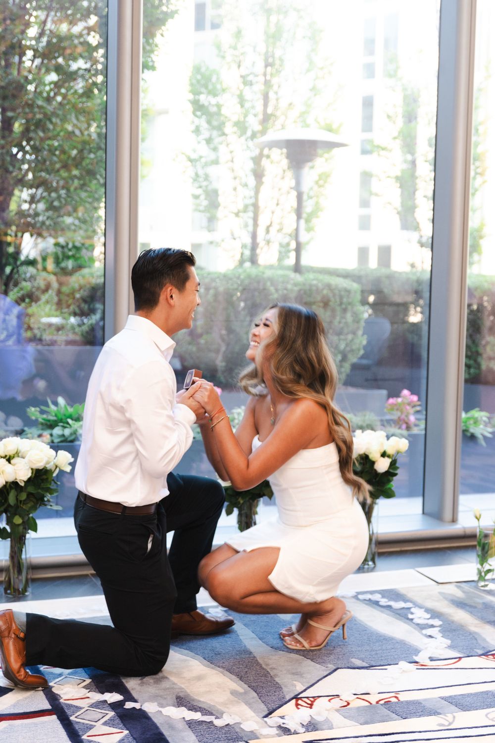 Candid proposal moment captured in sequence with natural lighting and floral decorations.