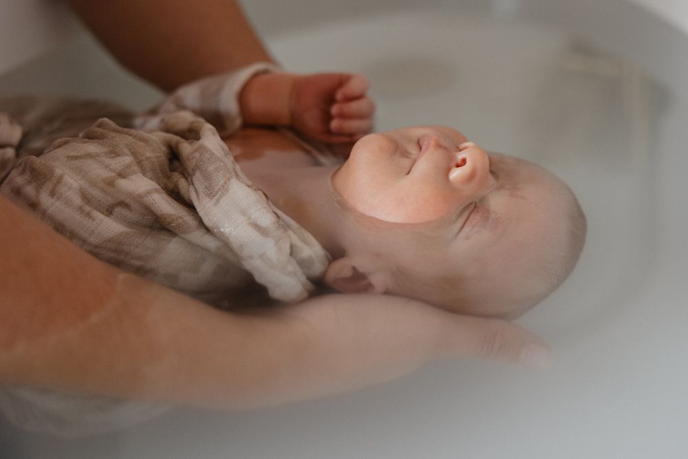 Moment de bien-etre d’un nouveau-ne dans un bain de Sonia, pris par une photographe professionnelle pres de Lille.