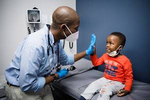 Doctor performing a routine check-up on a young patient, creating a calm and reassuring environment, brand shoot by Rynali Photography.