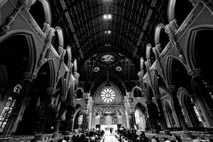 Stunning black and white wide-angle shot of a grand Gothic cathedral filled with wedding guests.