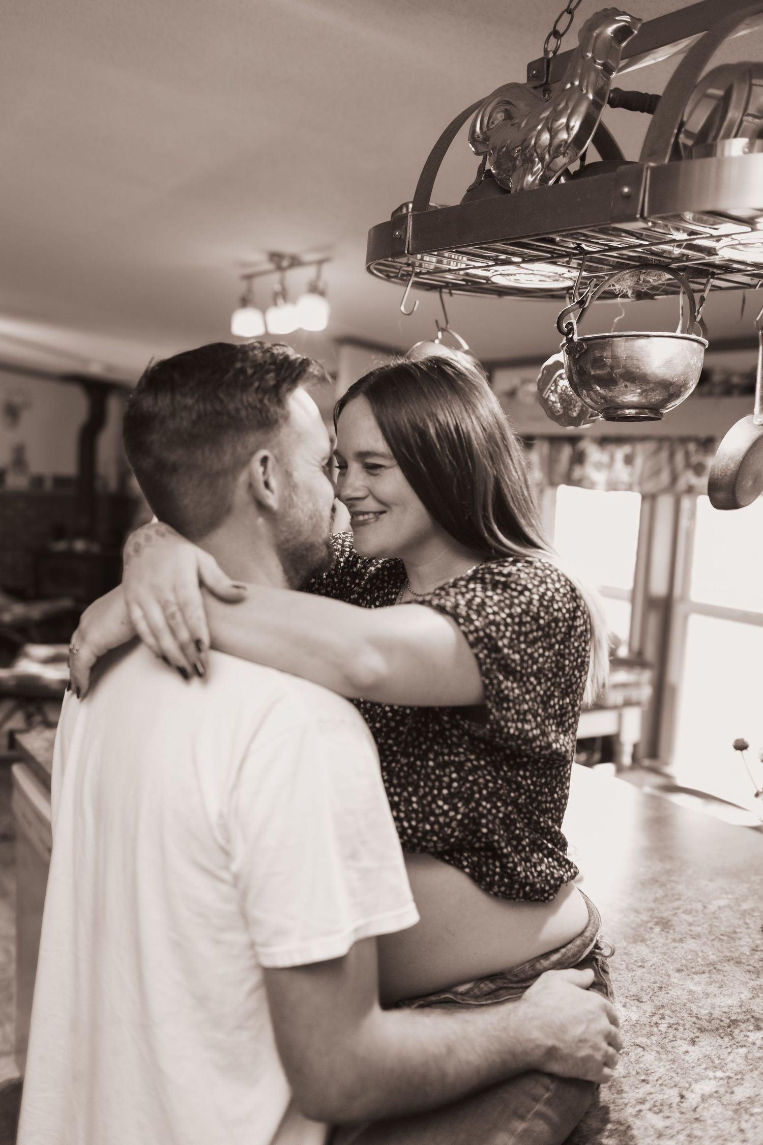 Couple kisses in kitchen during a lifestyle shoot at their home near Middletown, OH. Photographed by Vicci Photo of Dayton, OH