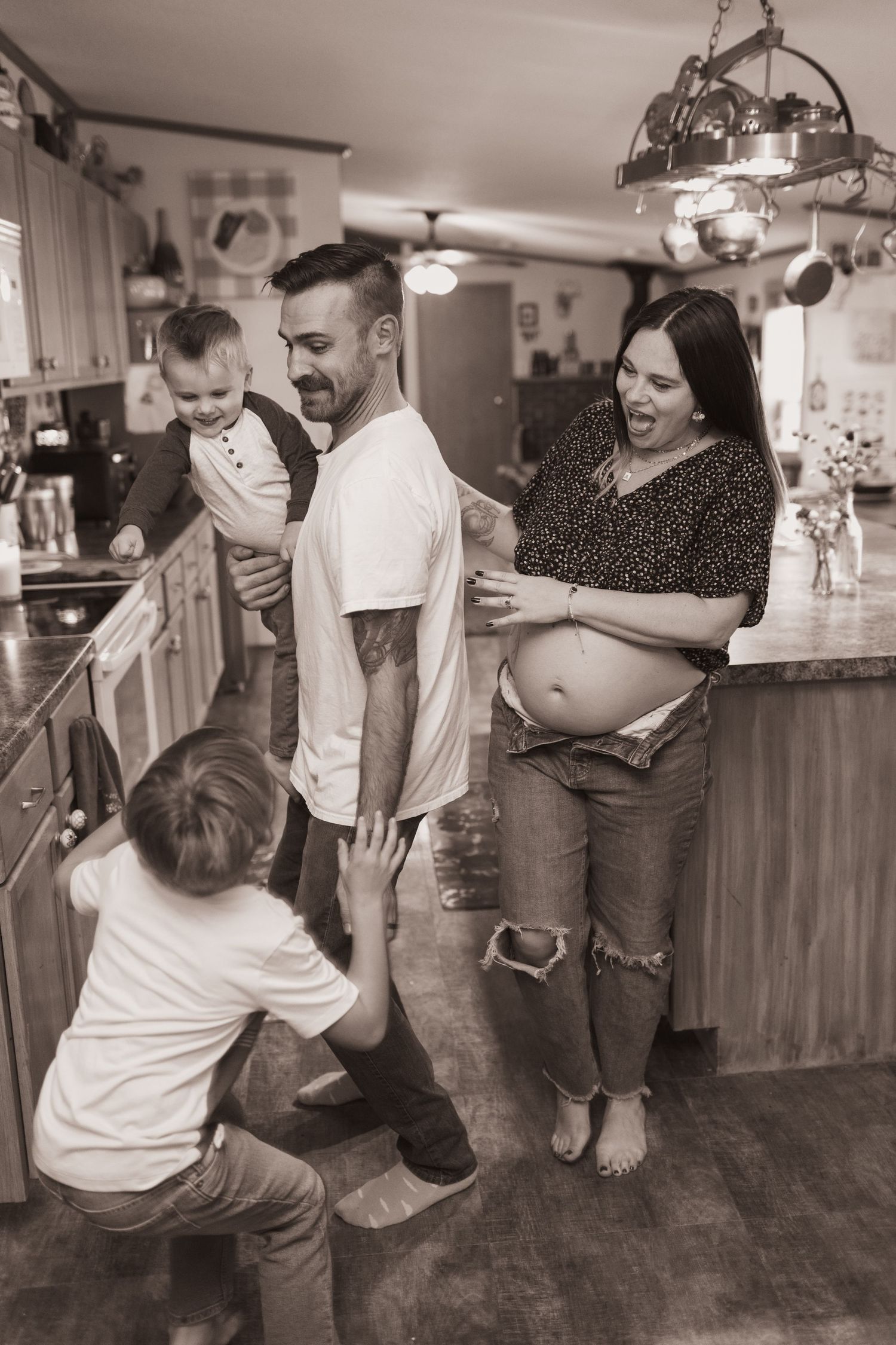 Family embraces in kitchen during a lifestyle shoot at their home near Middletown, OH. Photographed by Vicci Photo of Dayton, OH