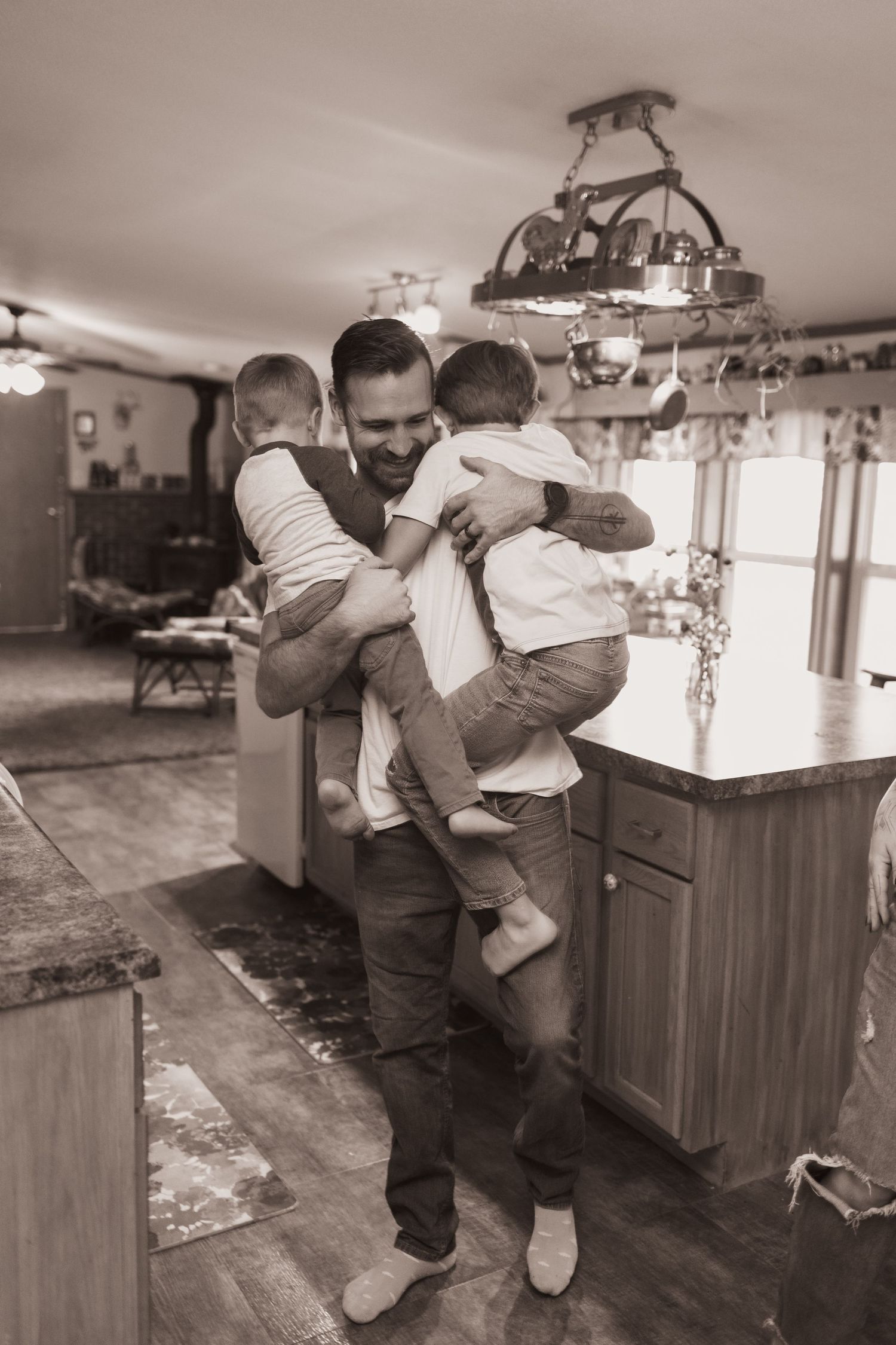 Family embraces in kitchen during a lifestyle shoot at their home near Middletown, OH. Photographed by Vicci Photo of Dayton, OH