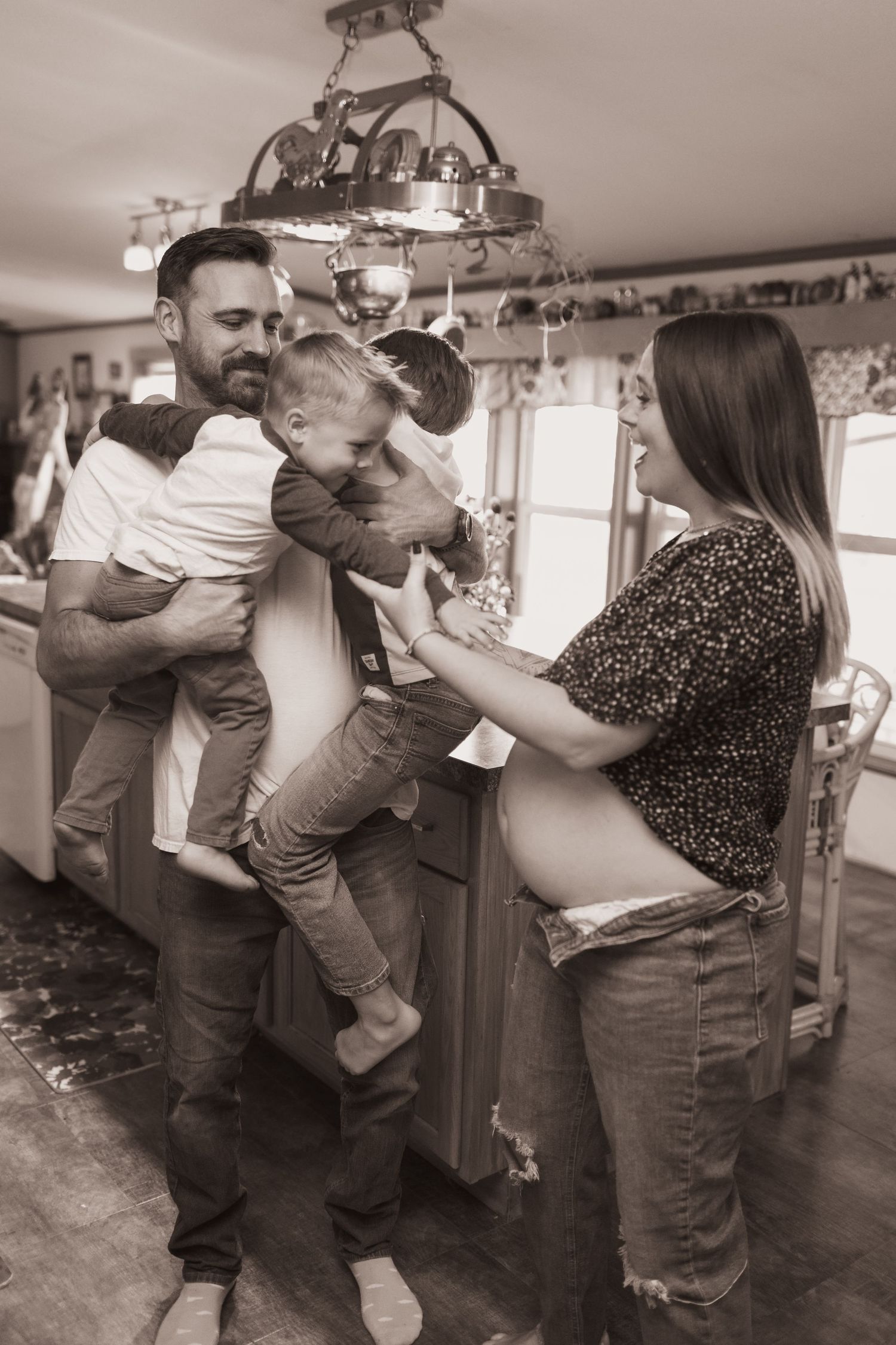Family embraces in kitchen during a lifestyle shoot at their home near Middletown, OH. Photographed by Vicci Photo of Dayton, OH