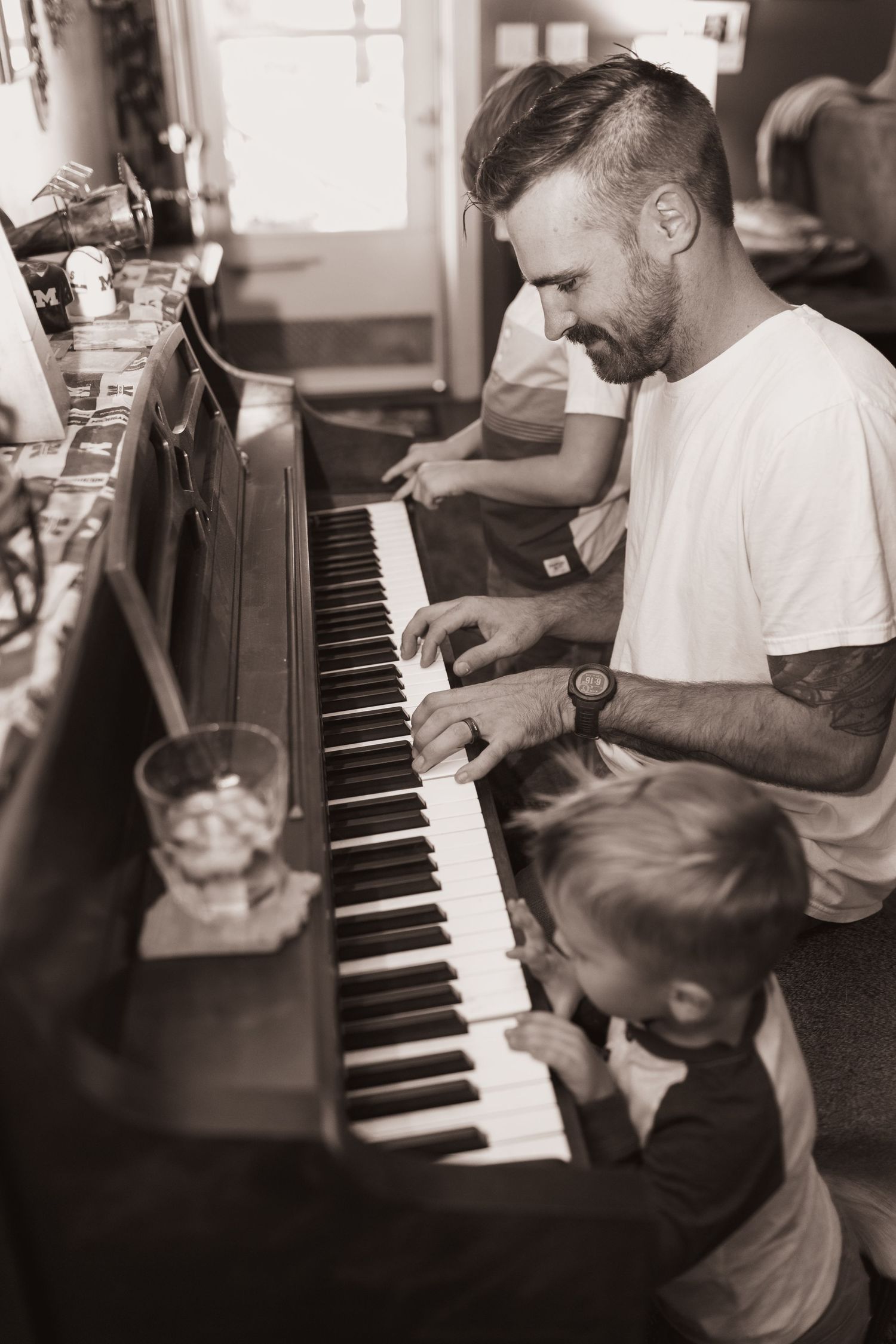 Family plays the piano during a lifestyle shoot at their home near Middletown, OH. Photographed by Vicci Photo of Dayton, OH