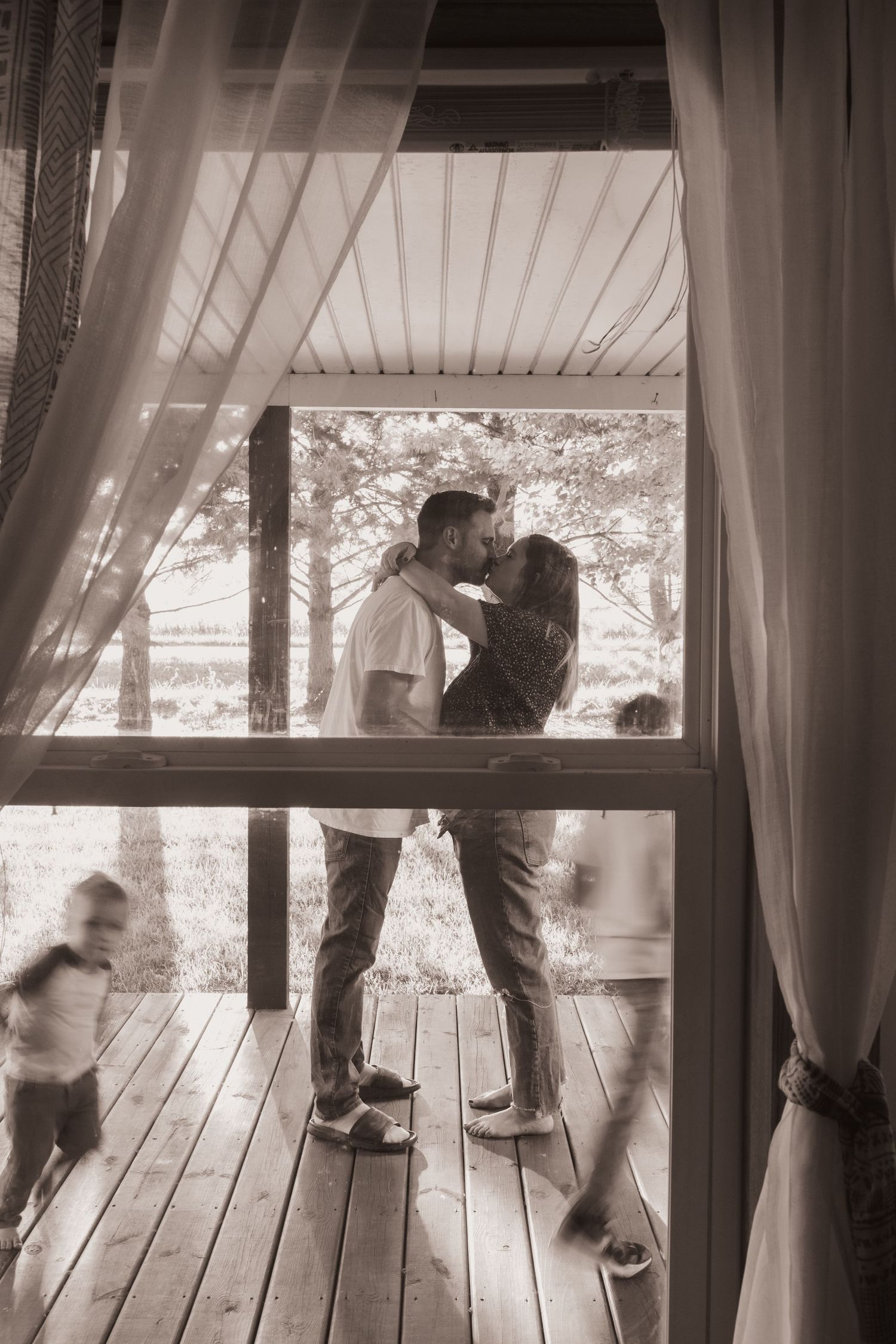 Family embraces on their porch during a lifestyle shoot at their home near Middletown, OH. Photographed by Vicci Photo of Dayton, OH
