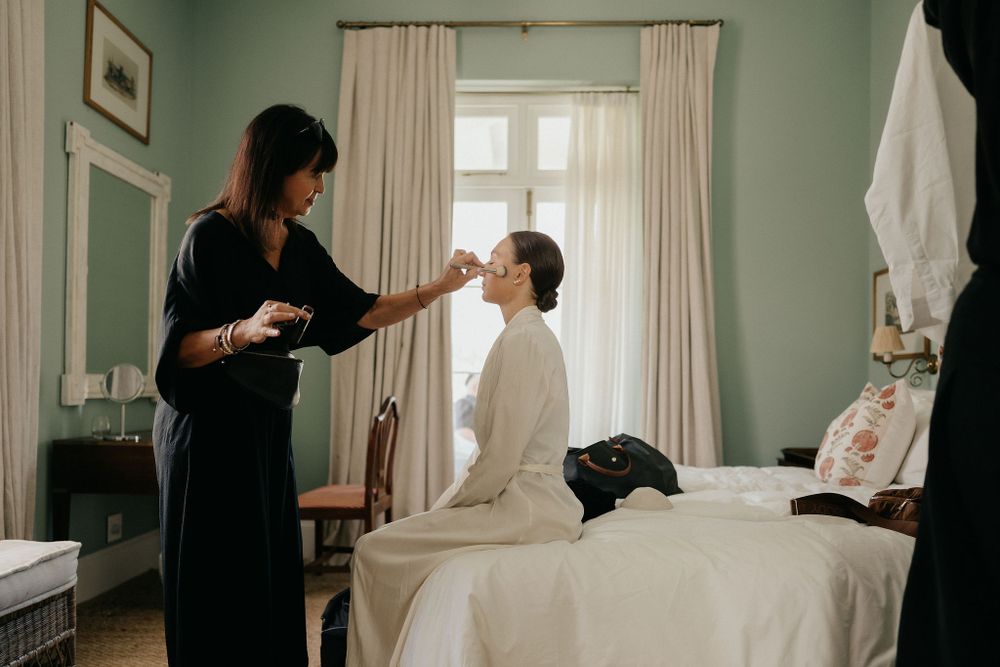 Getting ready for a special occasion in a tranquil bedroom with mint green walls and natural light streaming through windows.
