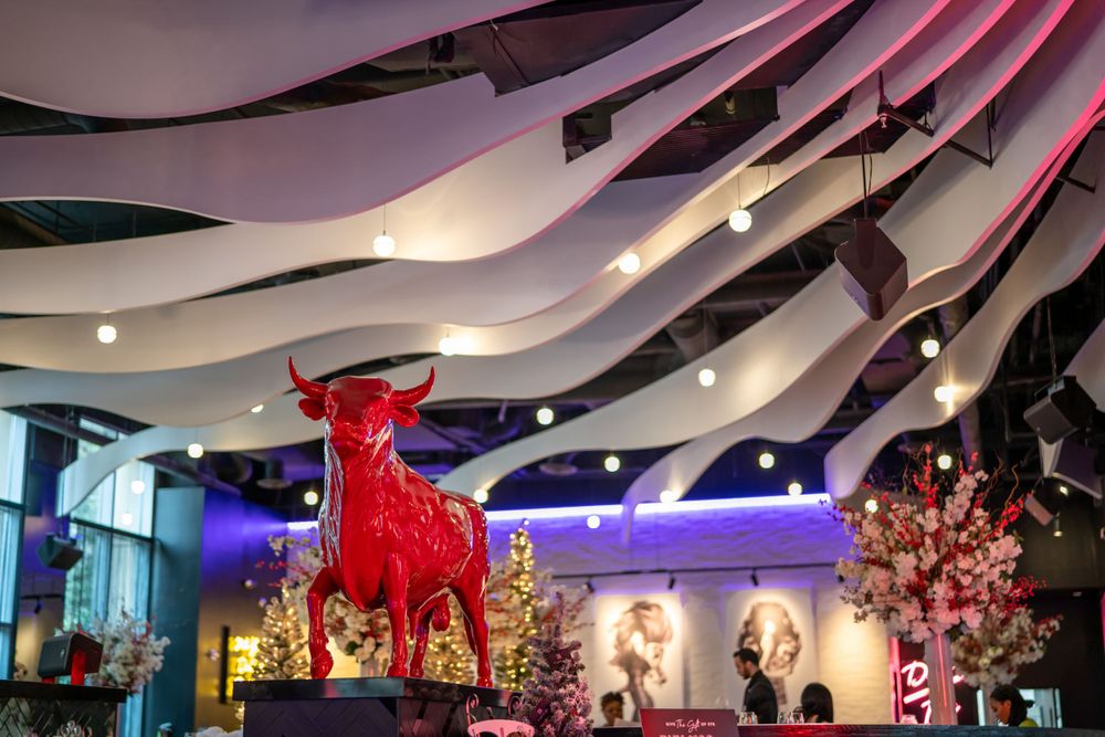 Shopping mall interior with curved white ceiling features and vibrant red decorative elements.
