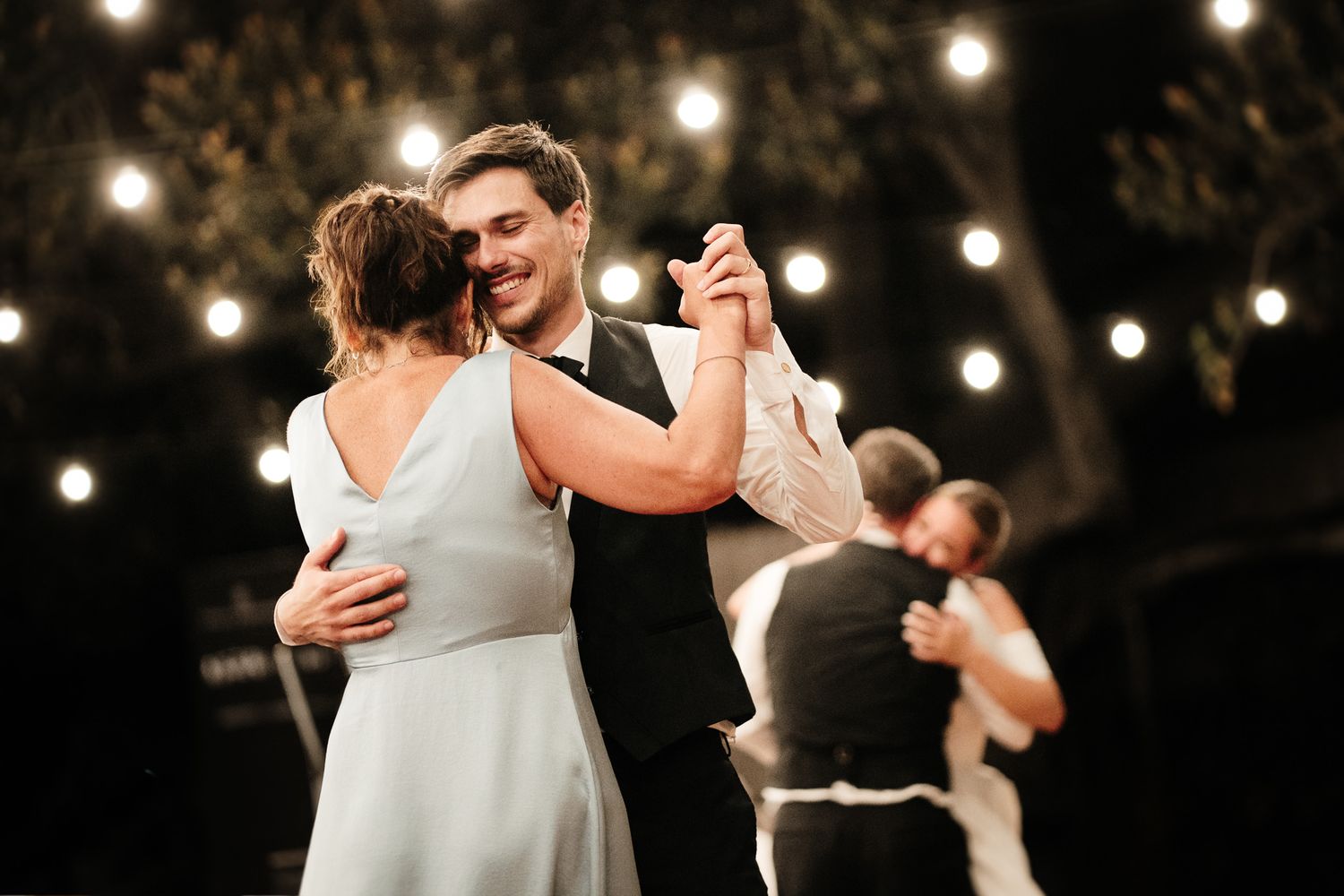 Due sposi ballano con i genitori durante la festa di matrimonio a Alassio. Fotografo di matrimonio in provincia di Savona.