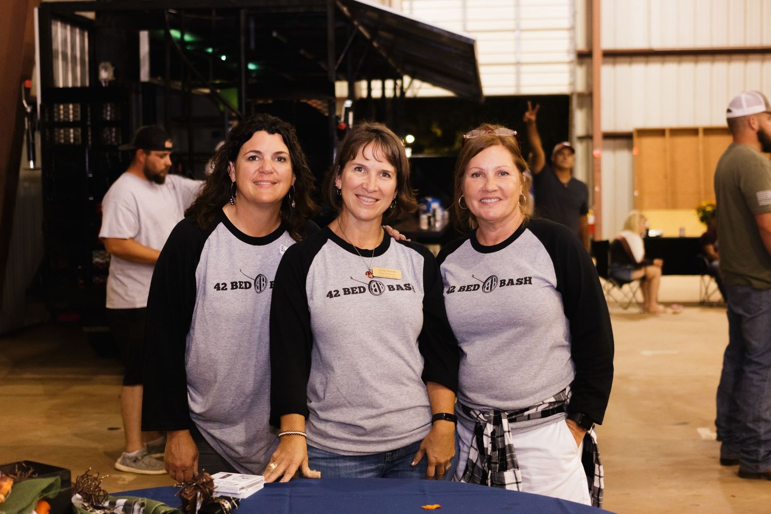 Three teammates wearing matching gray and black baseball shirts pose together. Denison North Texas Event Photography