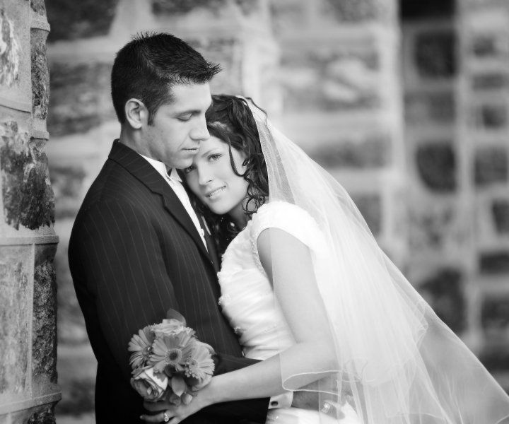 A tender black and white wedding portrait showing a close emotional embrace between newlyweds.