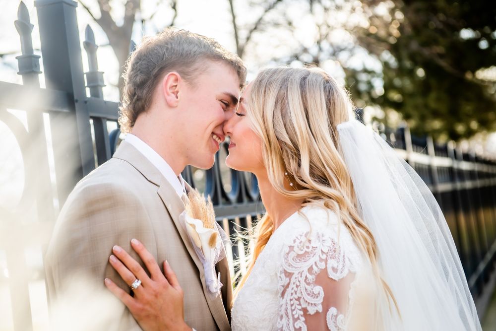 A tender wedding moment captured outdoors with soft natural lighting.