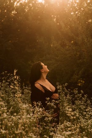 ritratto spontaneo controluce di una futura mamma in dolce attesa al tramonto.