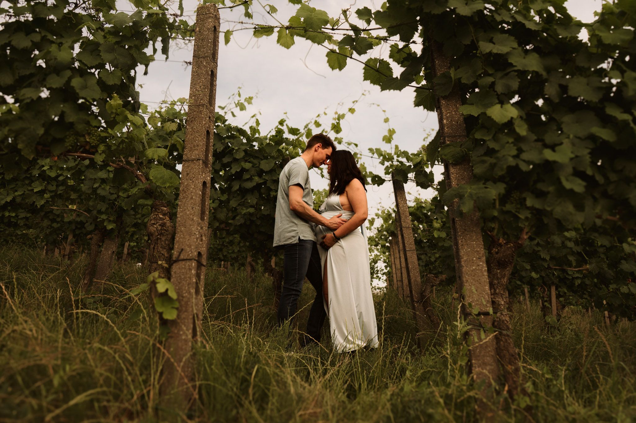 La coppia si abbraccia in un romantico vigneto nel Monferrato durante il tramonto.