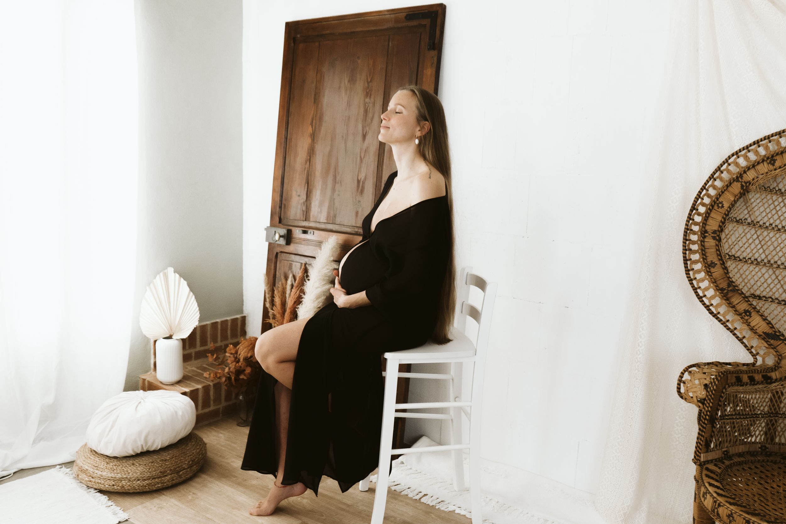 Ritratto di maternità artistico di donna in abito nero contro la porta vintage. Cassine AL.