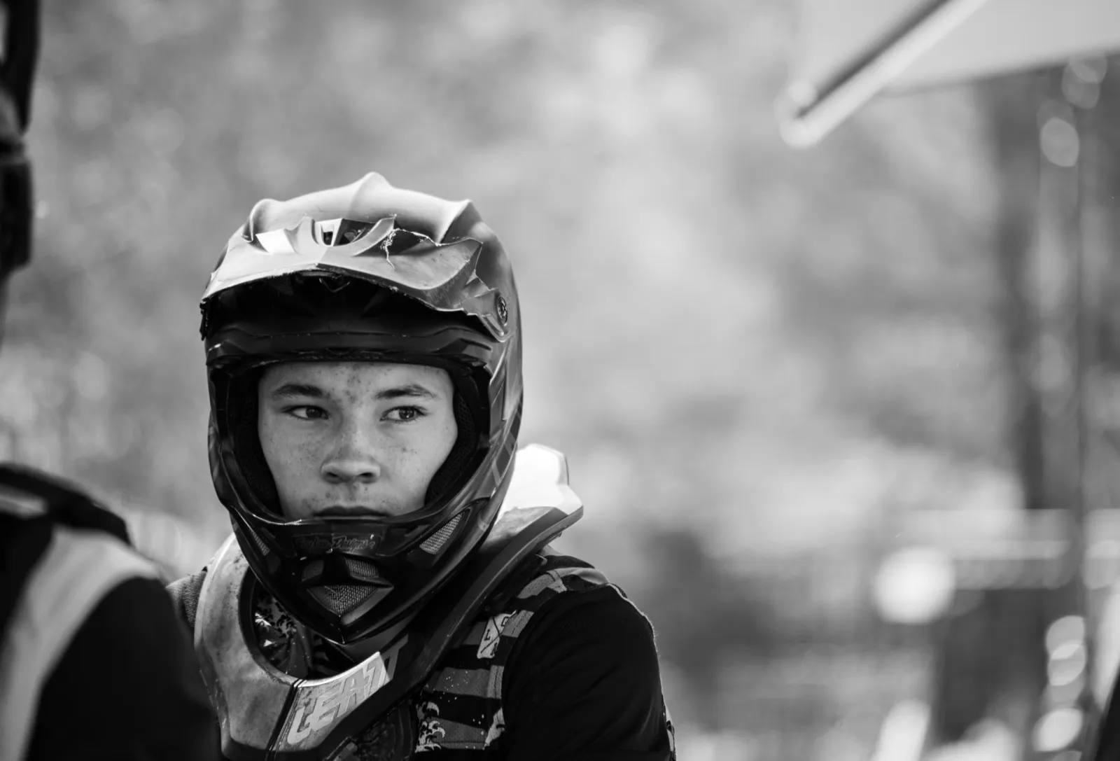 Portrait en noir et blanc d’un rider en casque intégral, regard sérieux.