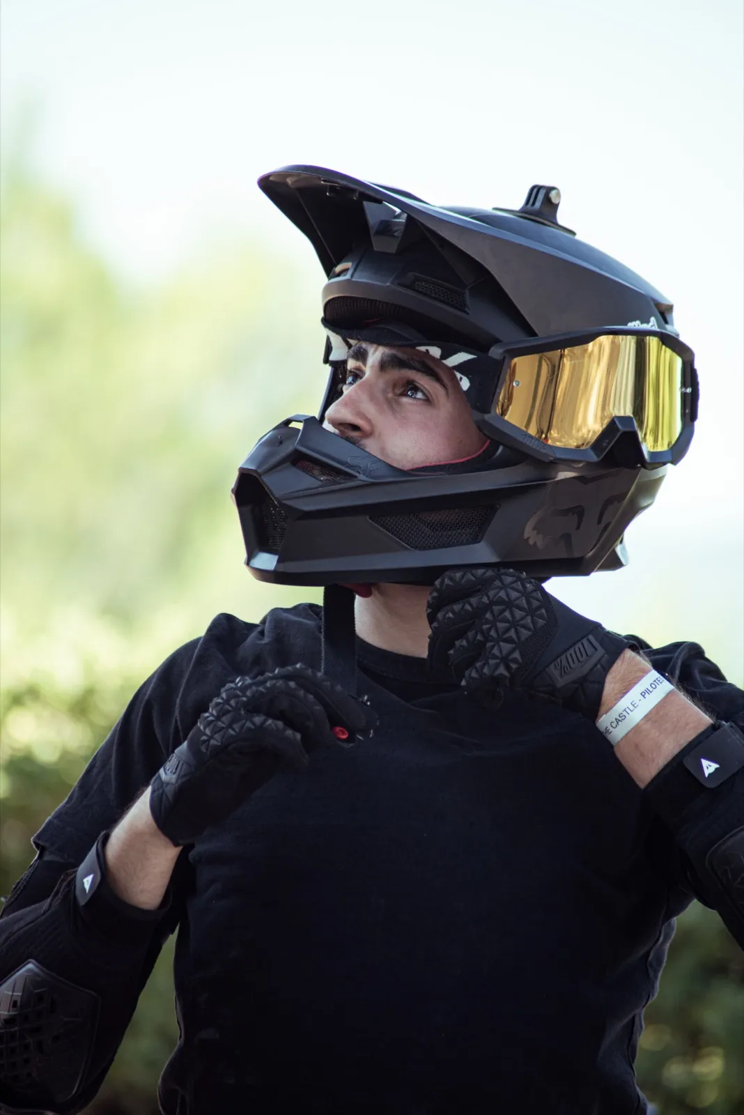 Portrait d’un jeune pilote en tenue intégrale, casque cross avec visière teintée.