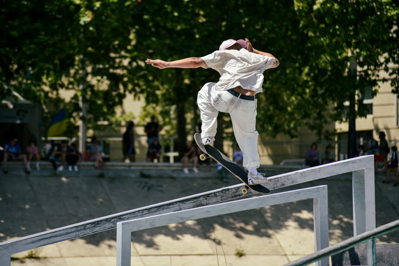 Skateur effectuant un grind sur un rail en pleine compétition urbaine.