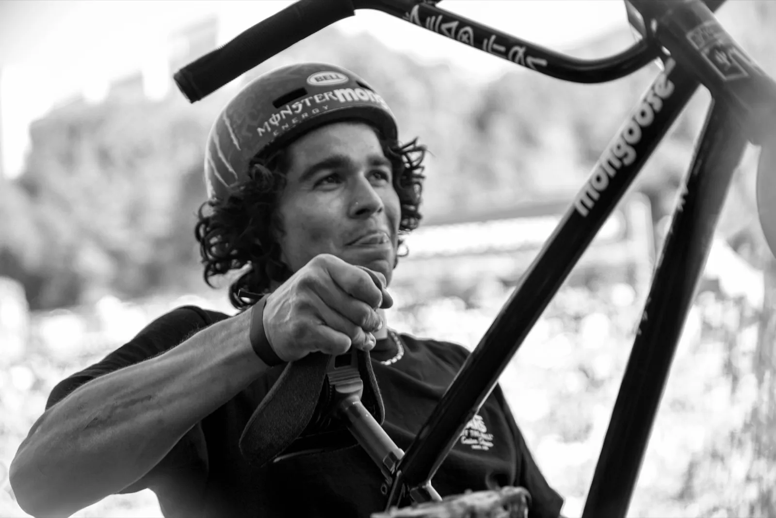Portrait en noir et blanc d’un rider tenant son guidon de BMX, regard intense.