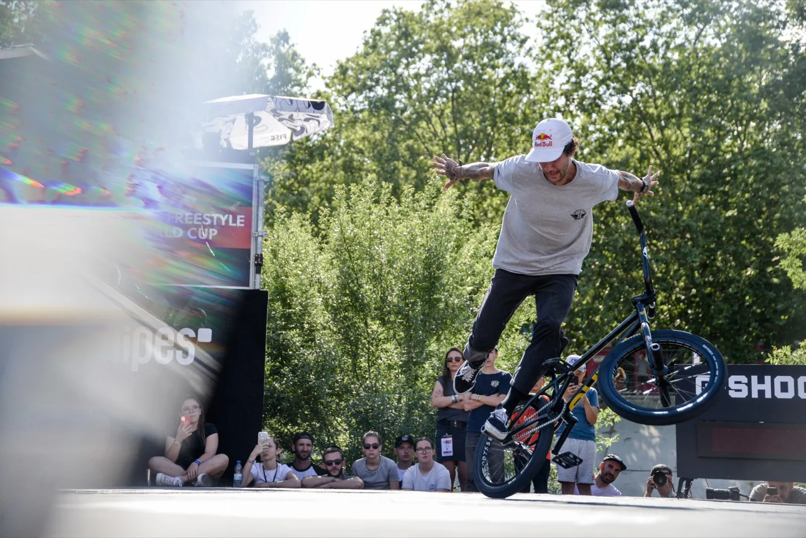 Rider en plein trick de BMX flat, équilibre sur une roue en pleine démonstration.
