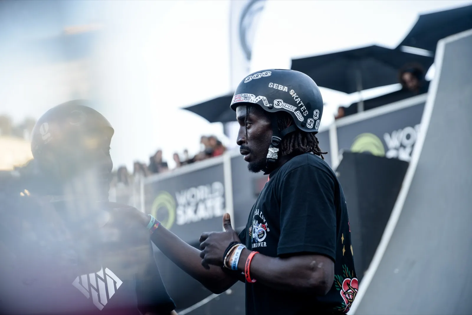 Portrait d’un rider casque sur la tête, au bord d’une rampe pendant un contest.