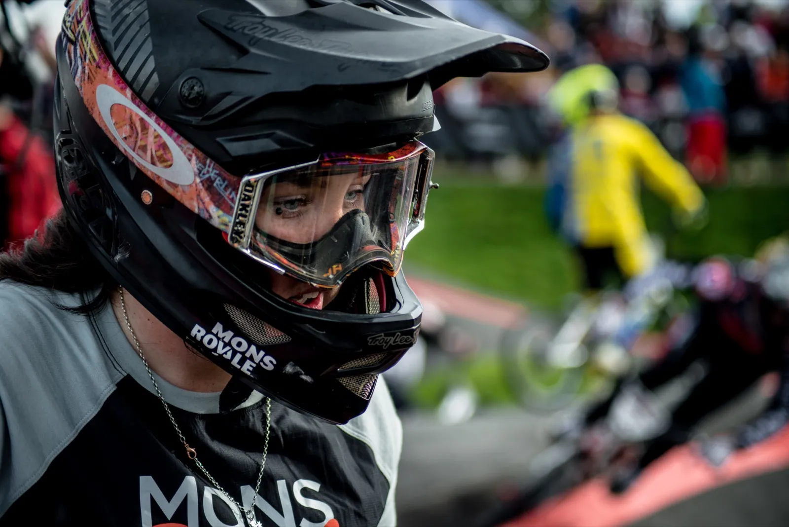 Portrait d’un rider BMX portant un casque intégral et des lunettes, prêt à s’élancer sur la piste.