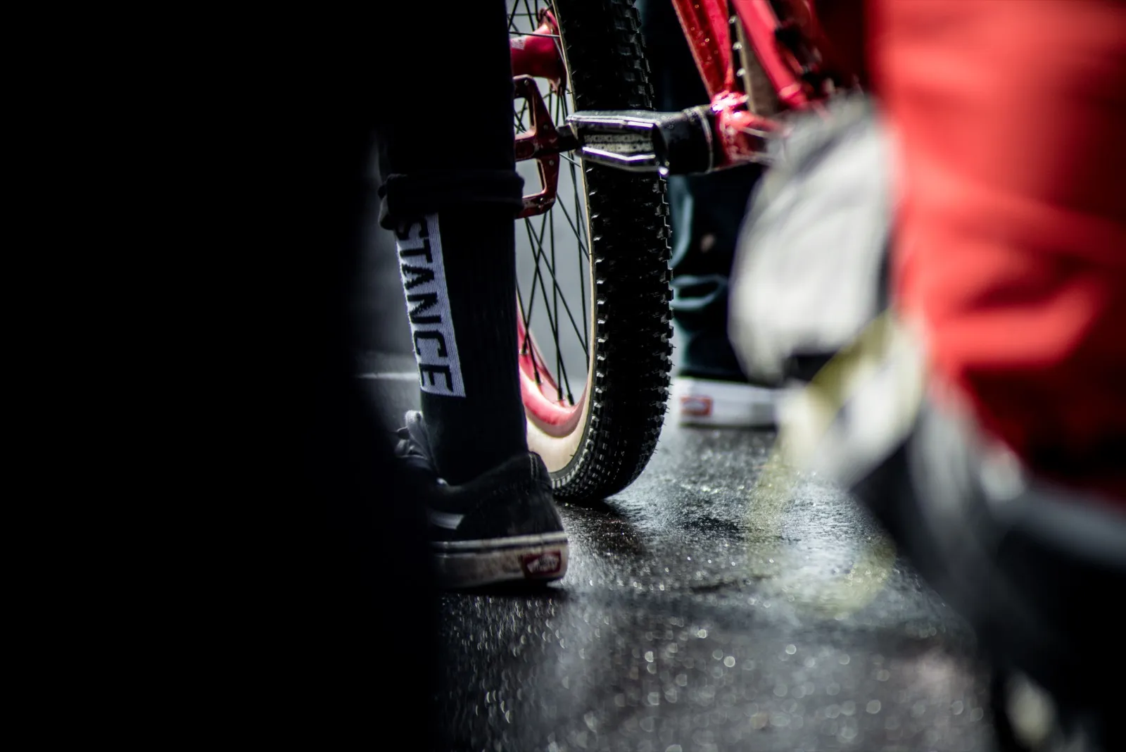 Vue basse de plusieurs roues de BMX sur un sol mouillé, dans l’ambiance d’une compétition.
