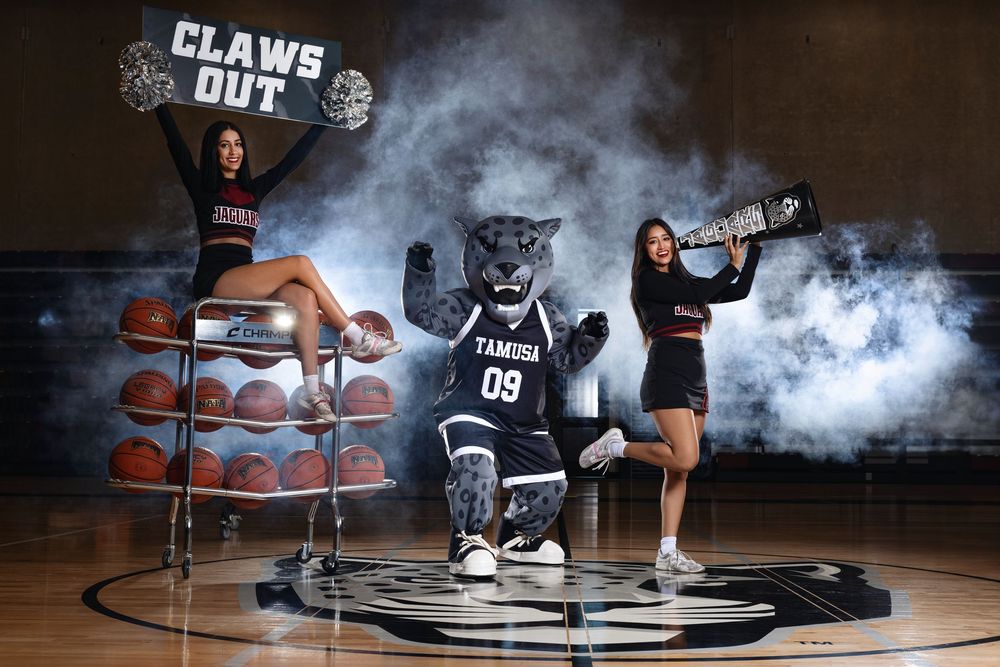 Basketball themed promotional photo with athletic figures and sports equipment arranged on a court with dramatic smoke effects.
