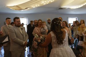 Wedding reception dance floor filled with celebrating guests under ceiling lights.