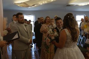 Wedding celebration with guests dancing and mingling in a decorated indoor venue.