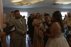 Wedding reception scene with guests dancing and celebrating in an indoor venue.