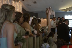 Wedding reception venue decorated with string lights and filled with celebrating guests.