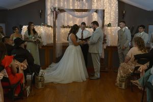 Wedding reception in a decorated venue with string lights and dancing guests.