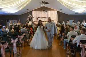 Panoramic view of a wedding reception venue with ceiling fans and decorative lighting.