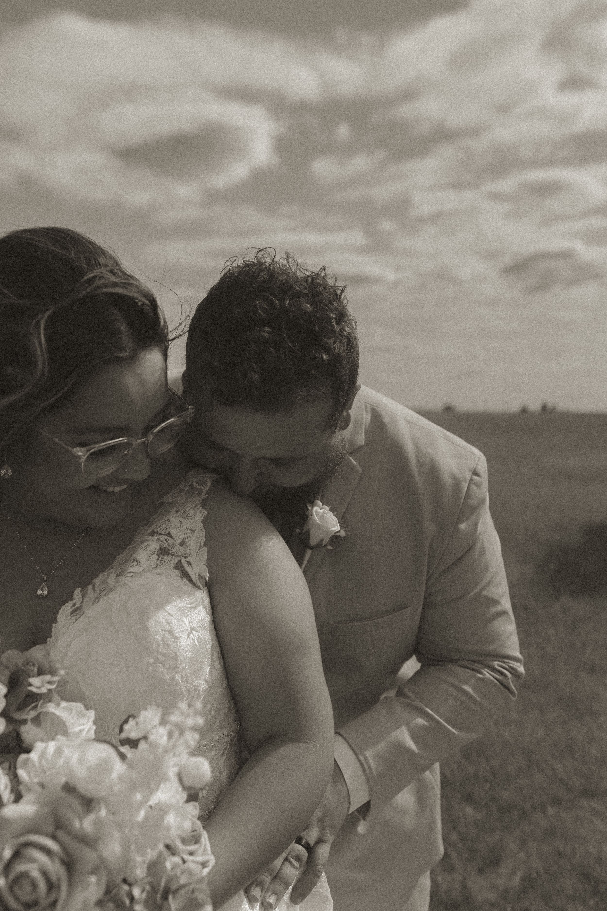 Black and white intimate wedding portraits captured in a field.
