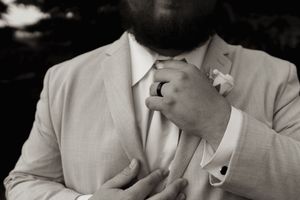 Close-up black and white portrait showing details of a light colored suit and tie.