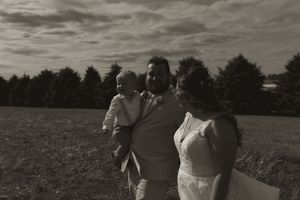 A dramatic black and white landscape photo of a wedding party in an open field.
