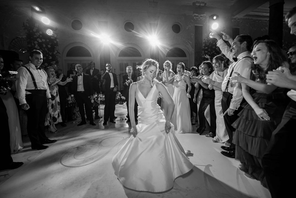 A group of wedding guests dancing on the dance floor during a lively reception celebration.