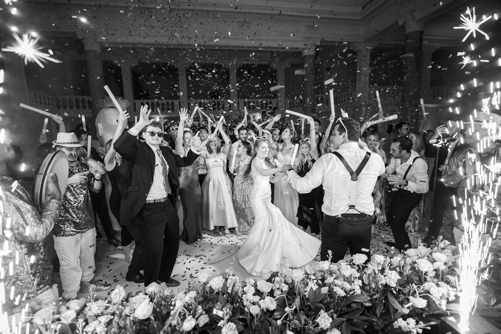 Wedding celebration with sparklers illuminating a dance floor filled with guests during a reception.