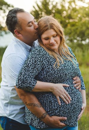 A couple in a tender embrace outdoors share romantic moments against a golden sunset background.