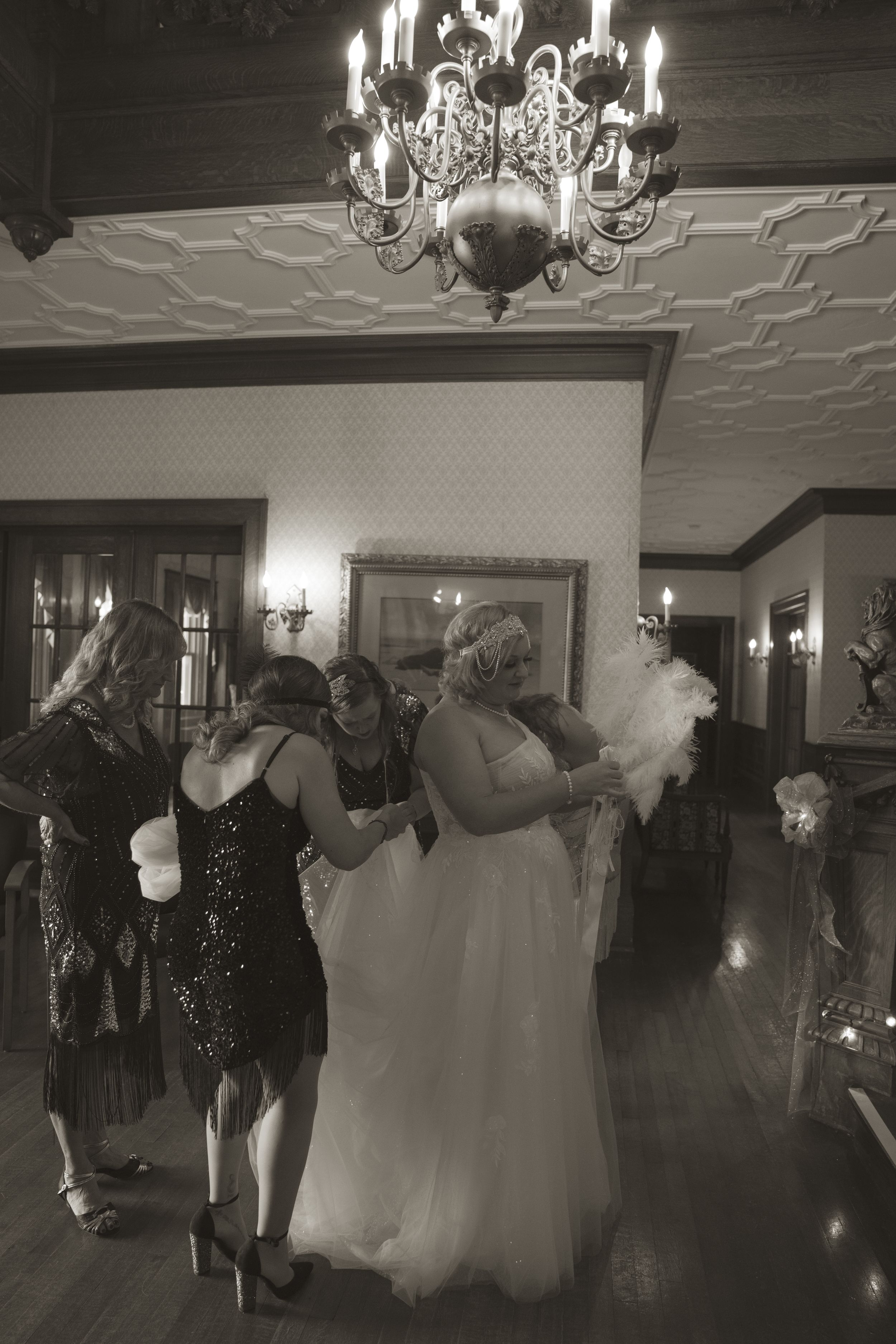 Wedding reception dance floor scene with elegant chandeliers casting warm light over the celebration.