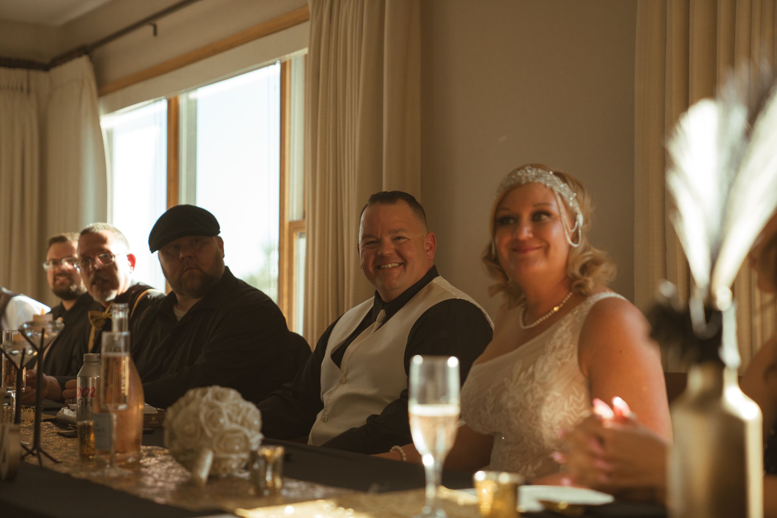 Wedding reception guests seated at tables in a warmly lit dining room.