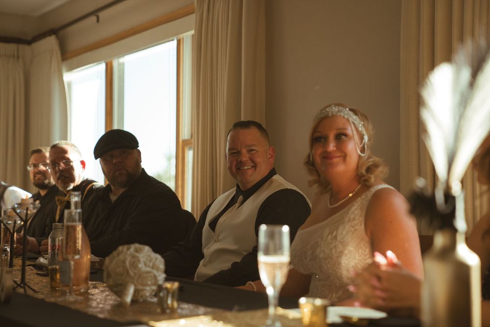 Wedding reception guests seated at tables in a warmly lit dining room.