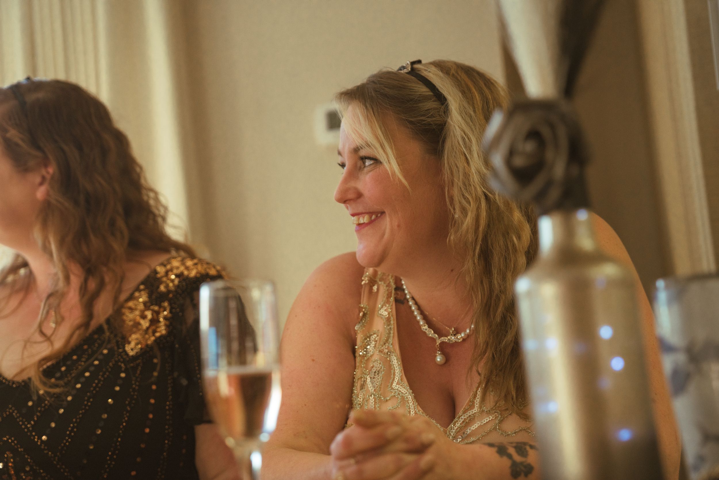 Wedding guests enjoy conversation at elegantly set dining tables.