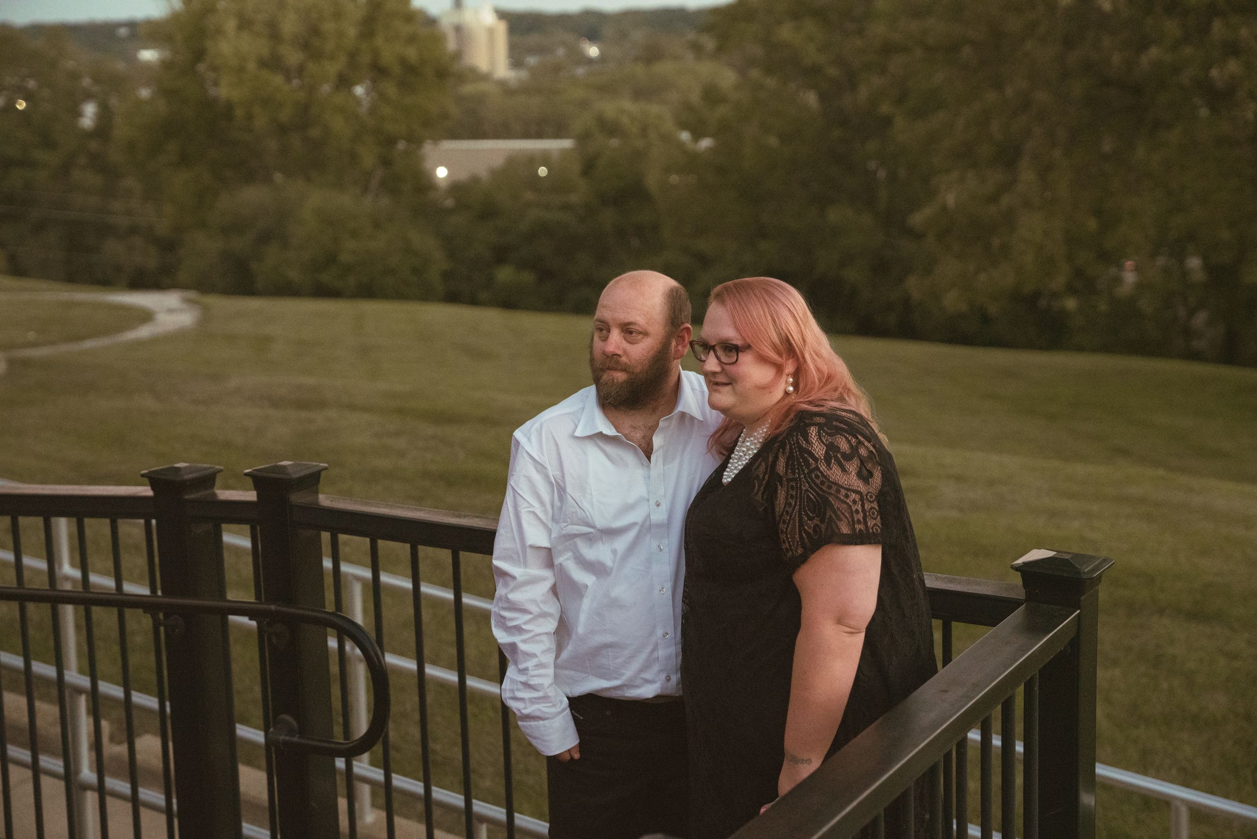 Wedding party enjoying sunset moments on an outdoor deck overlooking green landscape.
